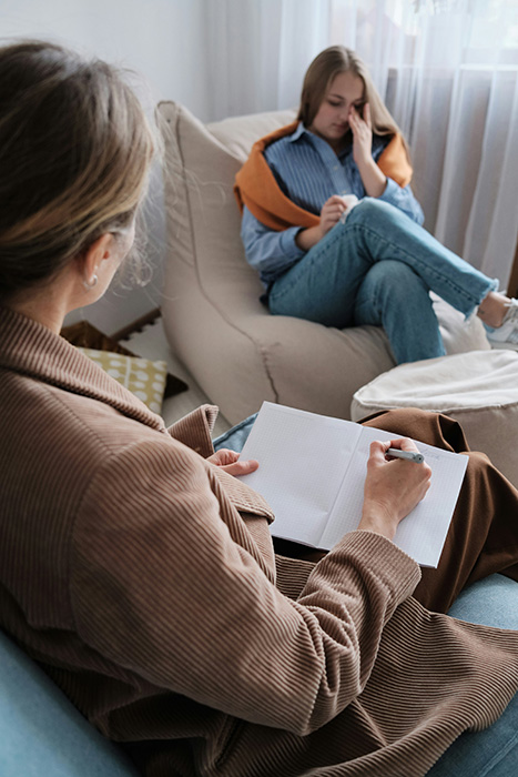A woman talks with her therapist during a trauma-informed treatment session.